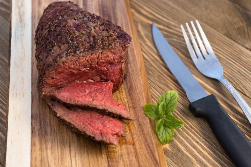 grilleld top sirloin steak with pepper crust on wooden board