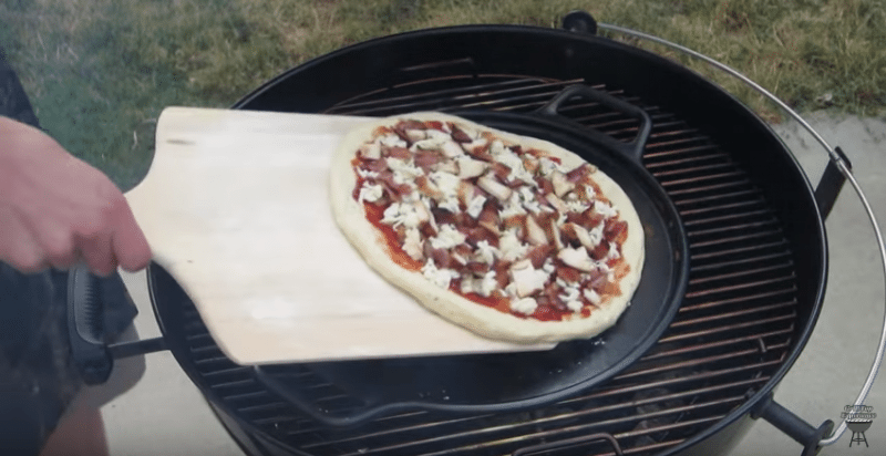 cast iron pizza pan on a weber charcoal grill