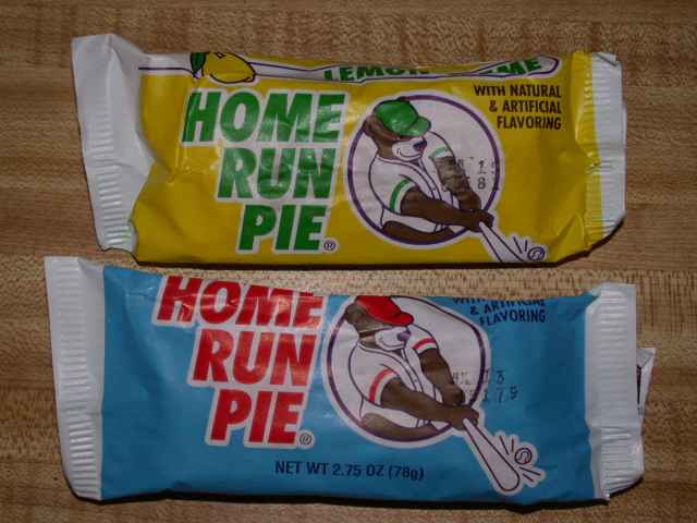 Two Home Run Pies on a wooden table. One is yellow and one is blue, and both show a bear playing baseball.