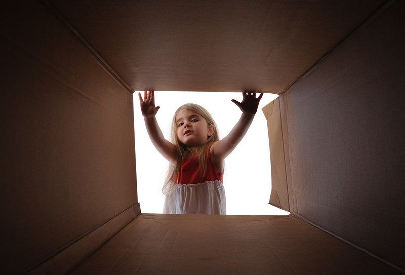 kid snack subscription boxes | Food For Net young female child looking into a kid-friendly subscription box with excitement