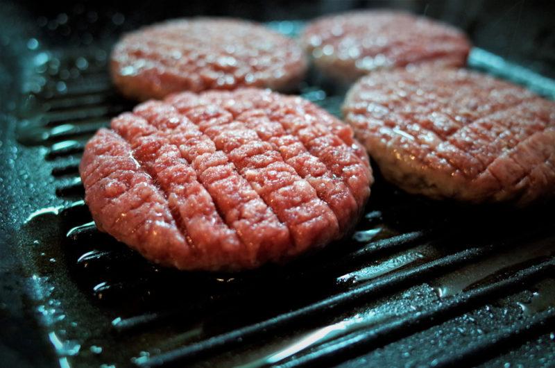 lean burger patties with fat drippings being grilled on fat reducing grill