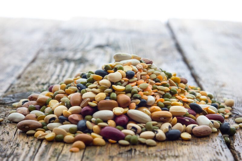 a closeup image of an aged wooden surface with a mound of legumes