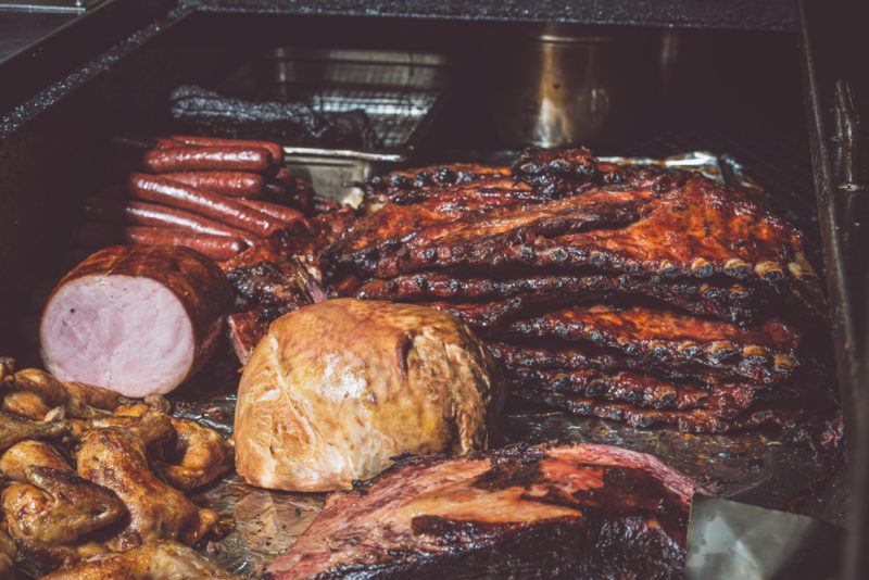 mixed meats in smoker looking delicious