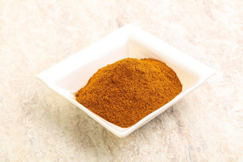 on a marbled surface is a squarish white dish with paprika powder