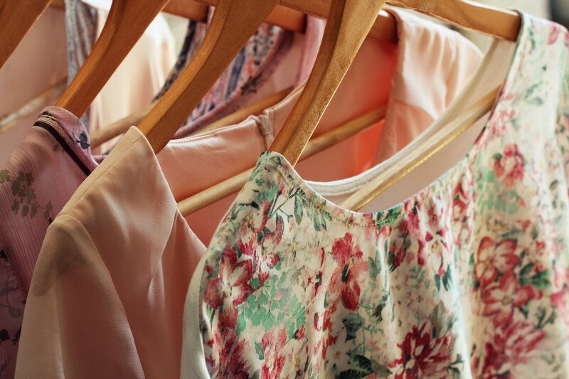 pastel dresses hanging on wooden hangers