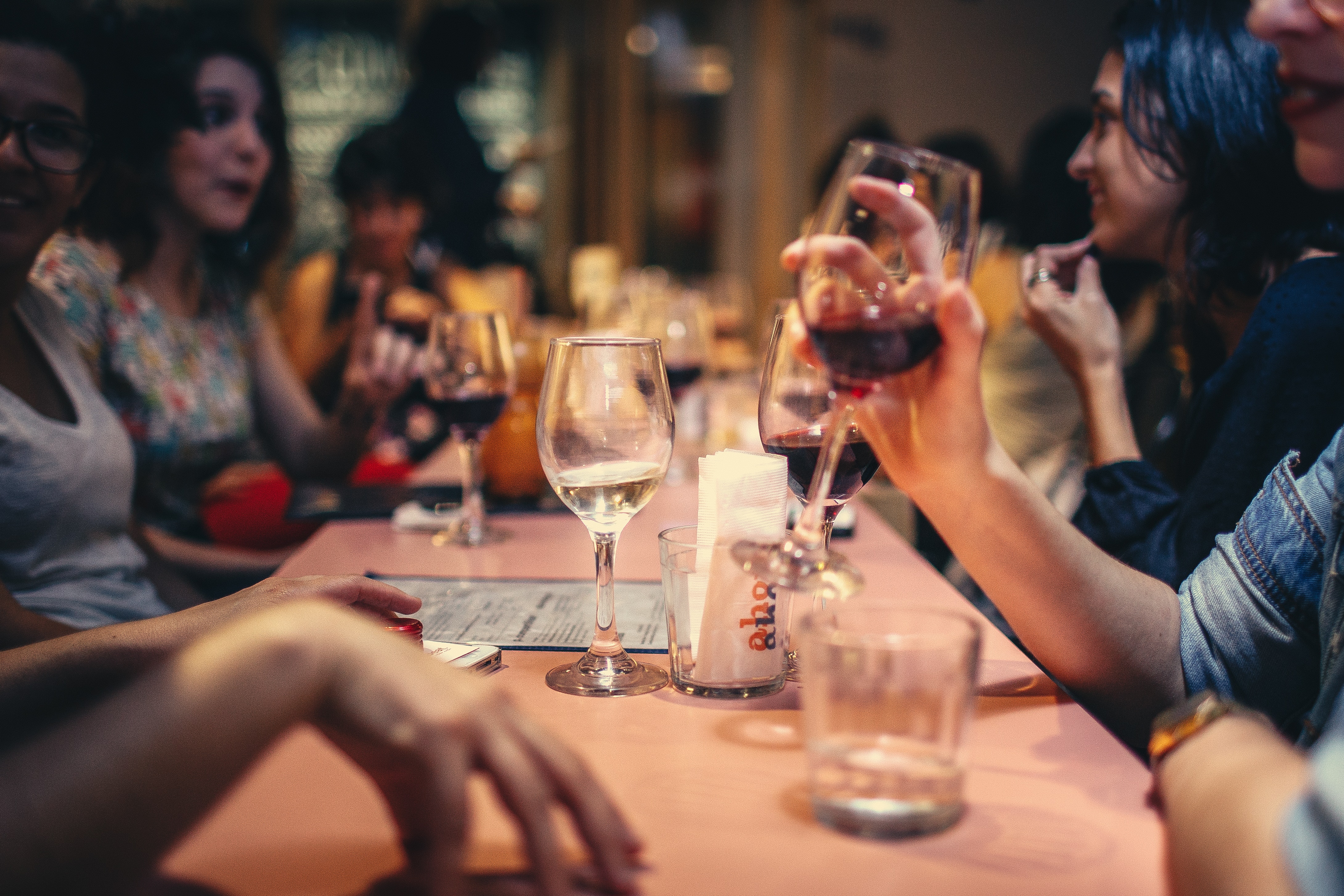 People drinking red and white wine while talking.