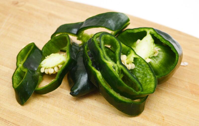 closeup image of sliced poblano peppers on a wooden board