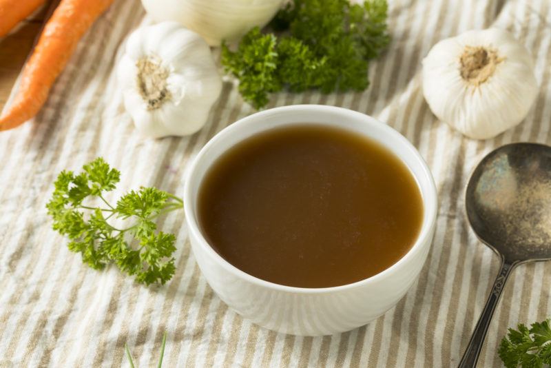 a cup of bone broth set on a placemat