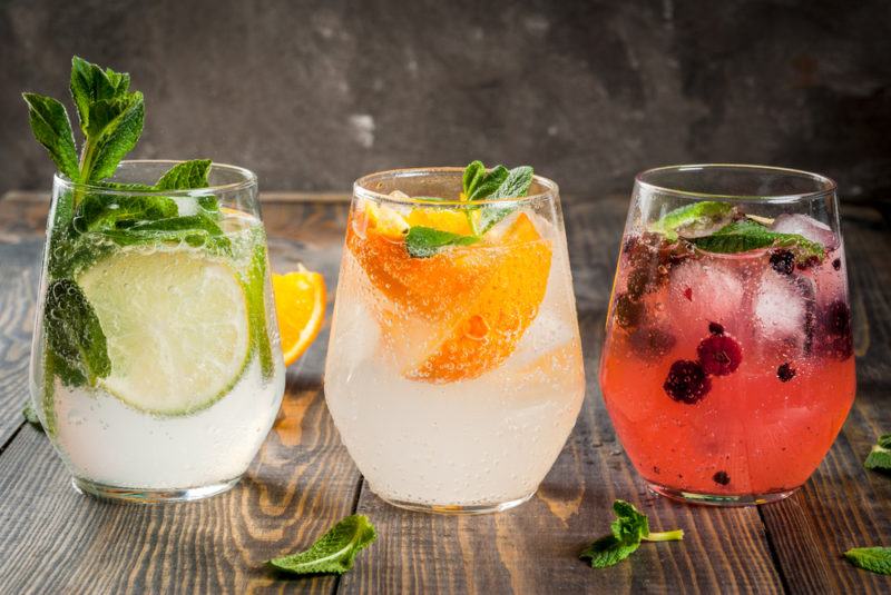 Three glasses of gin and tonic with different flavor combinations