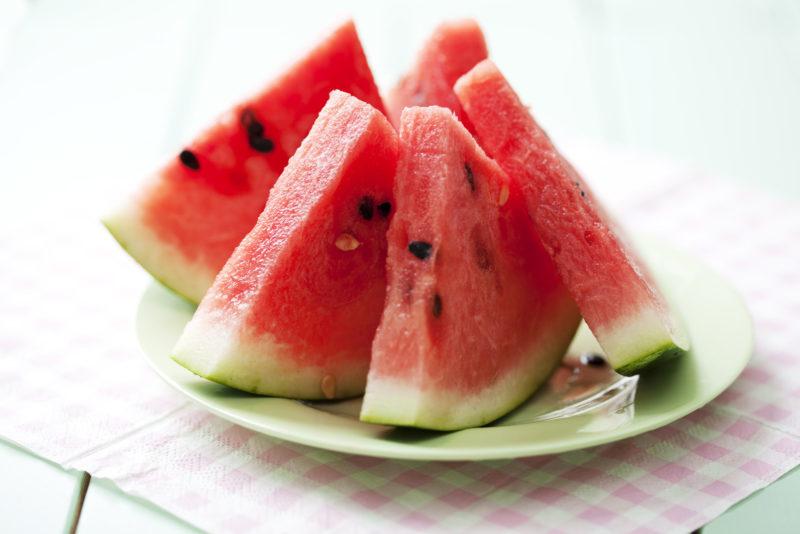 watermelon slices on a light green plate placed on placemat