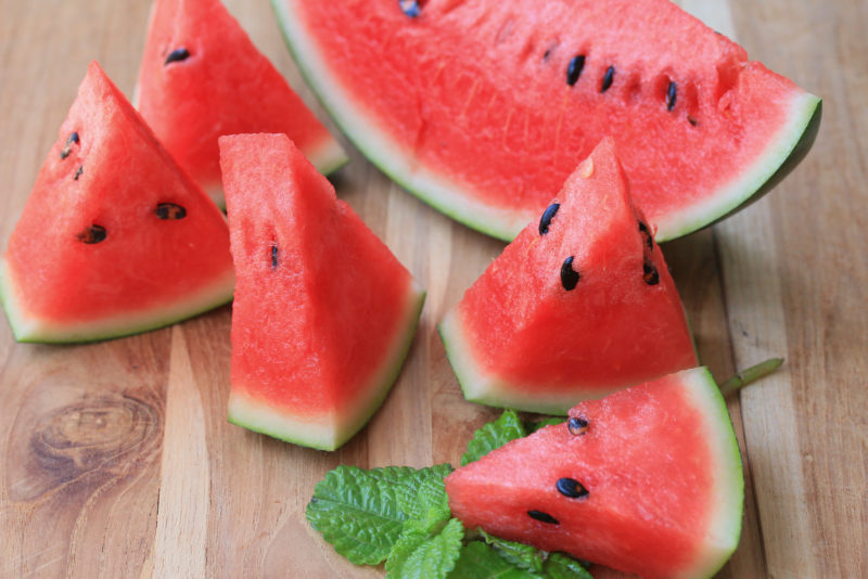 sliced watermelons on a wooden chopping board