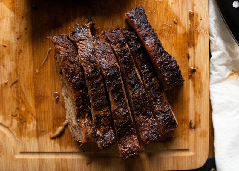 smoked brisket sliced on wooden cutting board