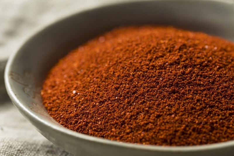 closeup image of a ceramic shallow bowl full of smoked paprika