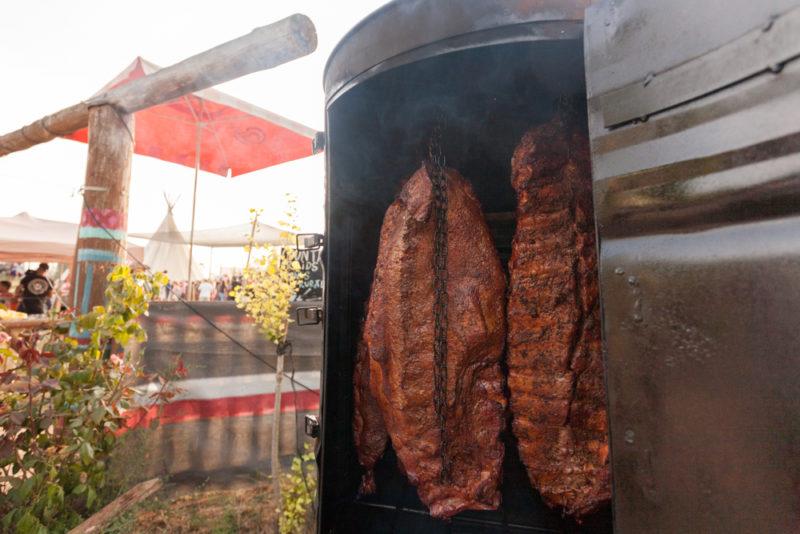 smoker opened with racks of rib hanging