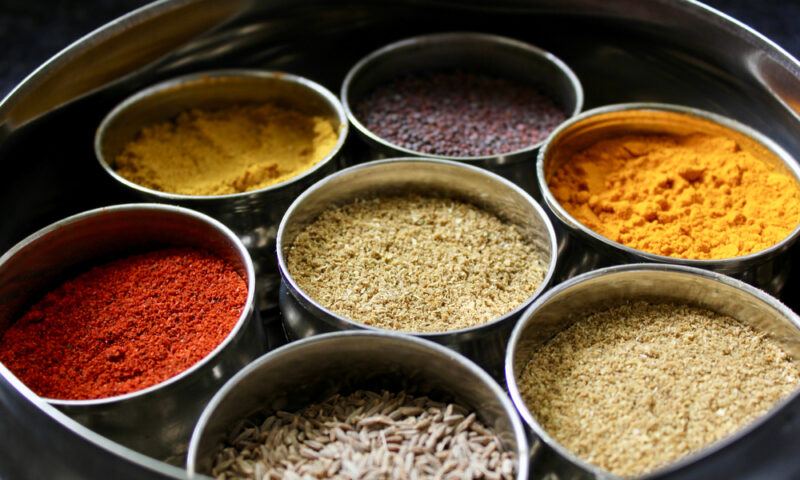 a round metal container with little metal round containers with different spices