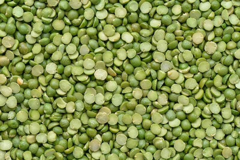 This photo shows a closeup view of several green split peas.