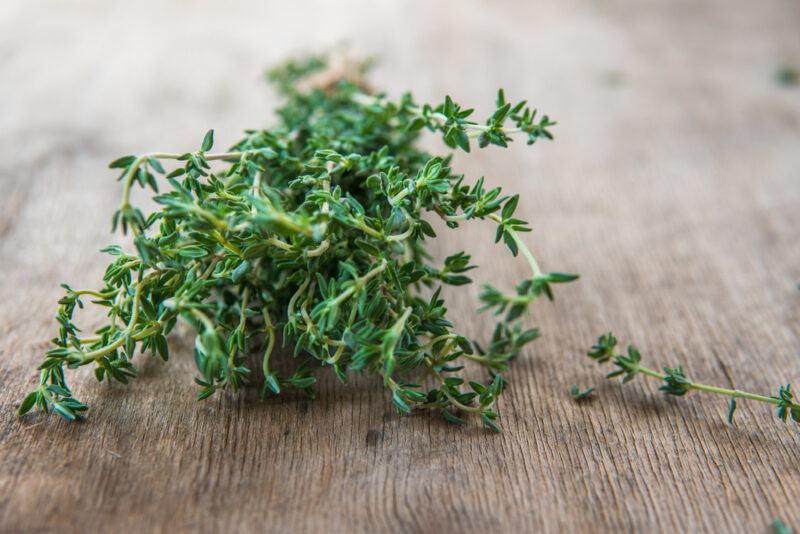 on a wooden surface is a sprigs of fresh thyme