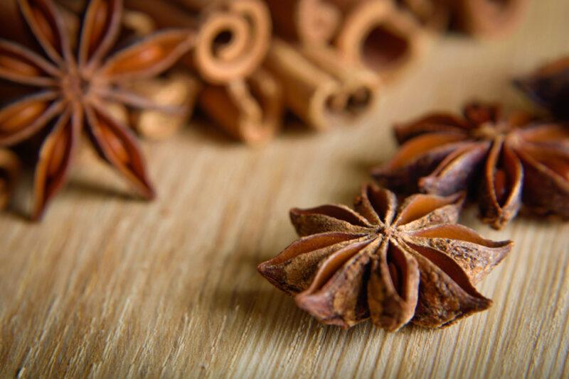 closeup image of a pile of star anise on a wooden surface