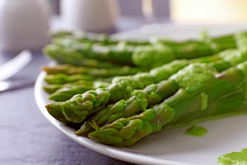 a closeup image of a white plate with steamed asparagus