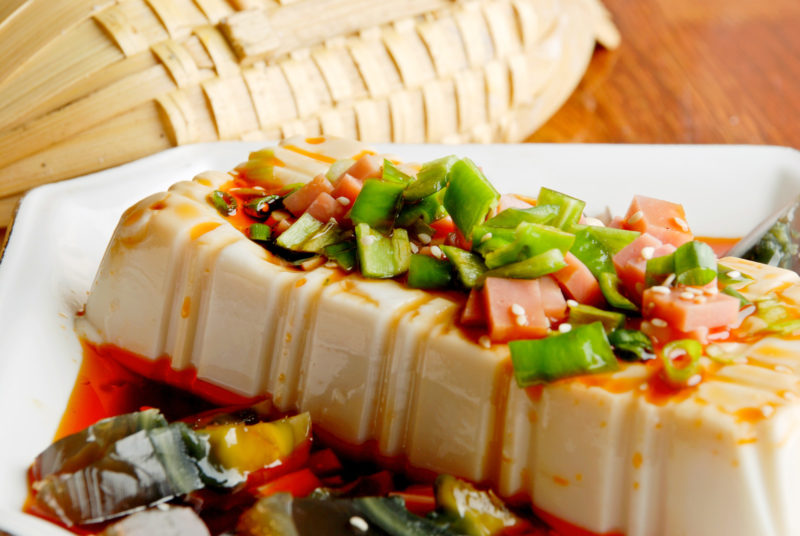 silk tofu served with century eggs on a white plate