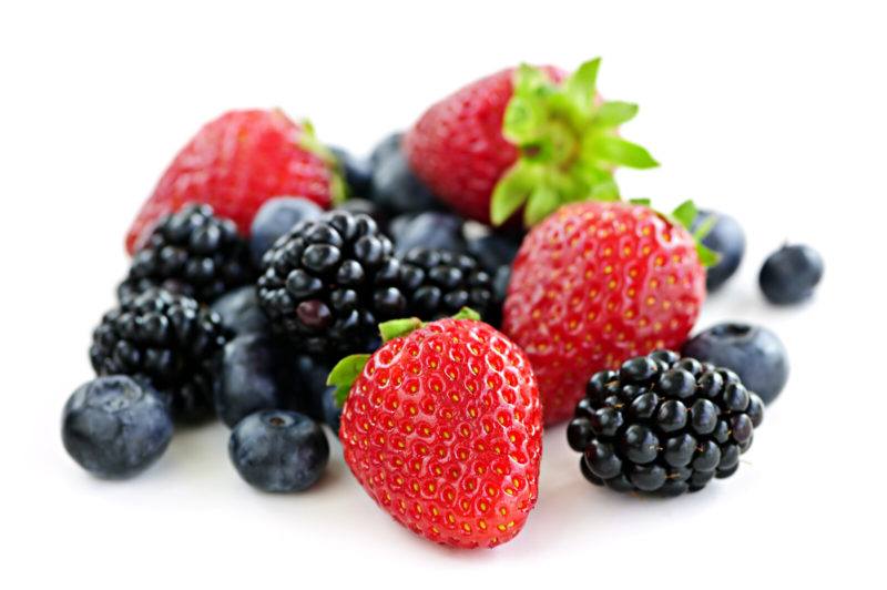 strawberries, blueberries, and blackberries on a white background