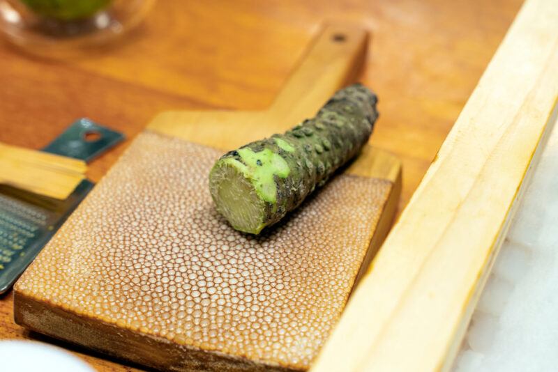 on a wooden surface is a wasabi root on a wooden grating board