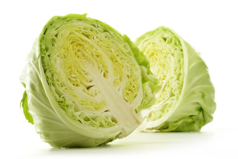 cabbage that has been cut in half, on a white background