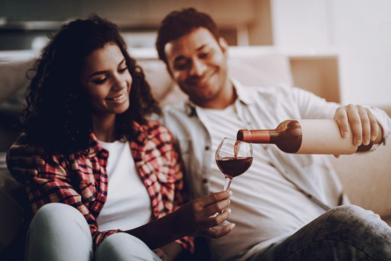 young couple drinking wine on couch